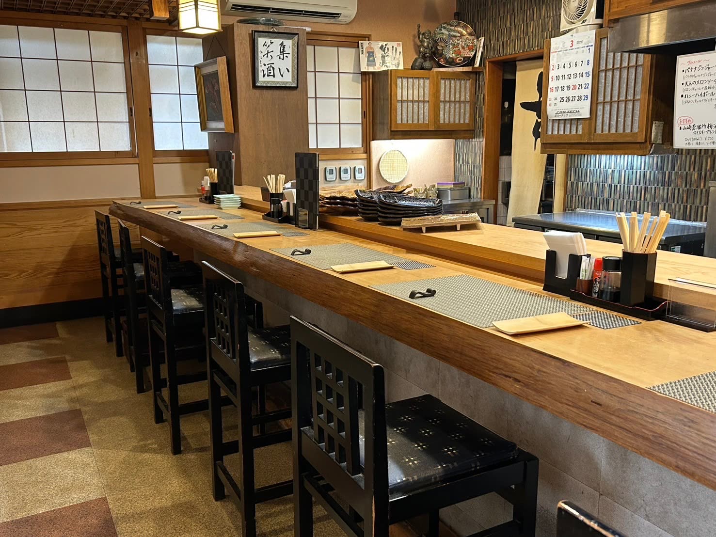 集い笑酒 太鼓のカウンター席。「集い笑酒」の書が掛かる