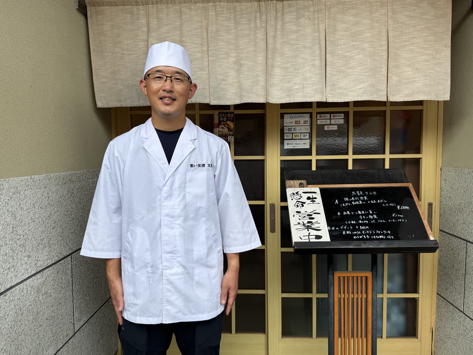 集い笑酒 太鼓の店先。のれんと本日のランチの黒板